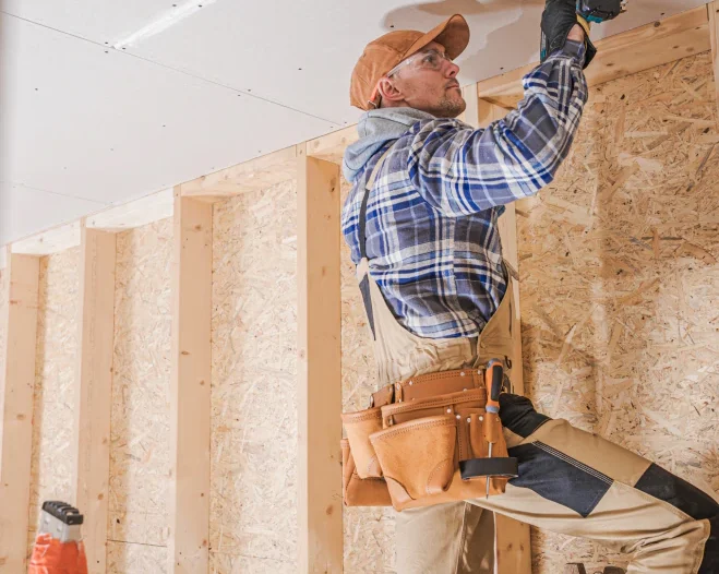 worker installing drywall